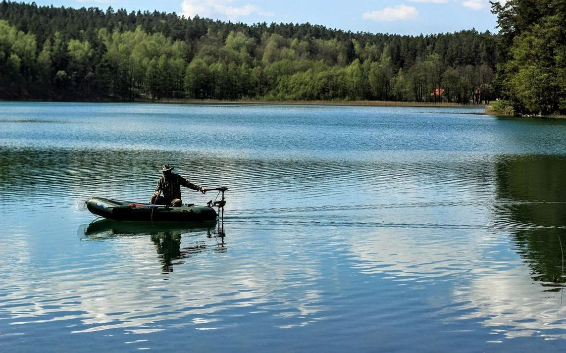 An angler with a caught fish held high on the water